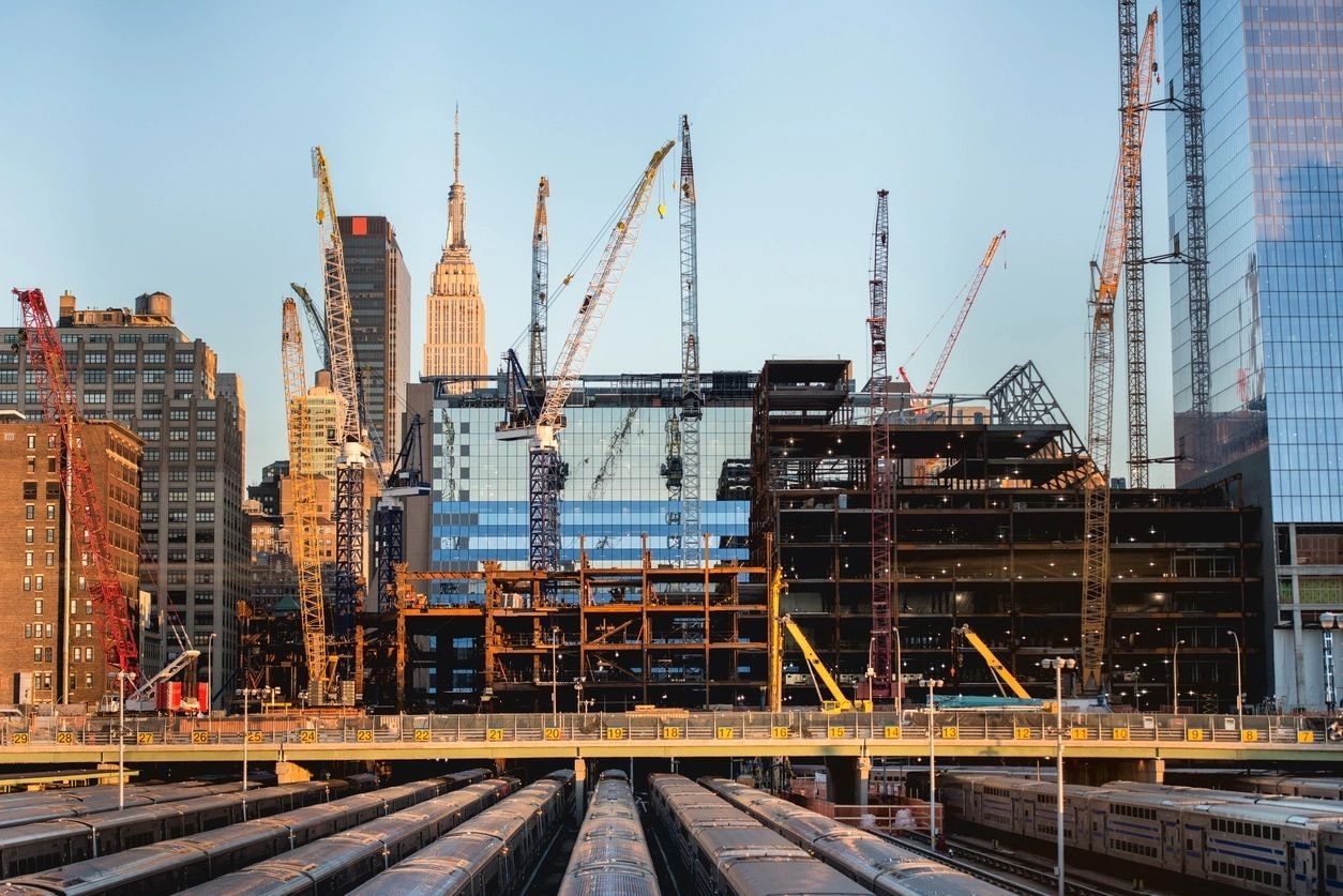 A construction site with many cranes in the background.